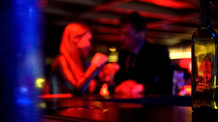 Fototapeta na wymiar Man first meeting with lady in nightclub, talking privately, romantic atmosphere