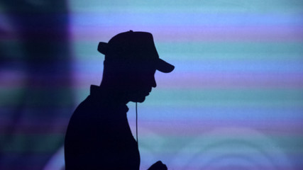 Male deejay silhouette on wall, dj performing for party guests, dancing to music