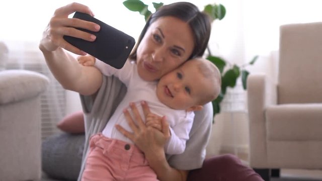 Mother taking selfie with adorable baby girl