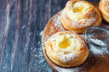 Homemade buns with ricotta and jam on a baking sheet.