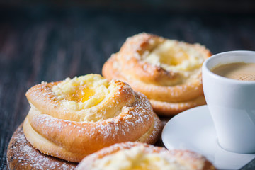 Homemade buns with ricotta and jam on a baking sheet.