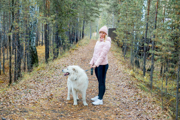 A pretty woman is walking her dog