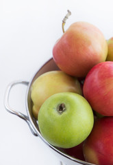 Fresh red and green apples in a collander / bowl