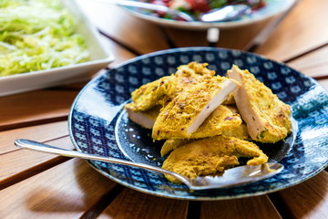 Cooked chicken in blue plate on wooden table. Selective focus.