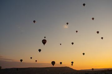 Beautiful sunset over Cappadocia, Goreme. Balloons flying against sky, aerial view. Most popular place in Turkey