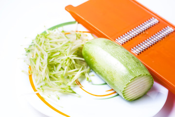 Grater and grated zucchini.