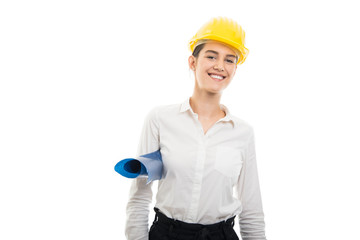 Young pretty woman architect wearing helmet holding blueprints