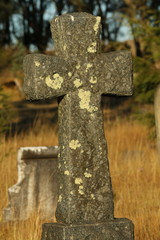 Ancient gravestone carved from granite and covered in lichen.
