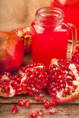 fresh fruit pomegranate on a wooden table with pomegranate juice in the jug