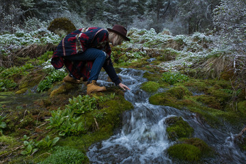 Obraz premium Stylish hipster girl in hat in autumn forest. Traveler woman exploring woods. Travel and adventure concept. Expedition vacation, space for text