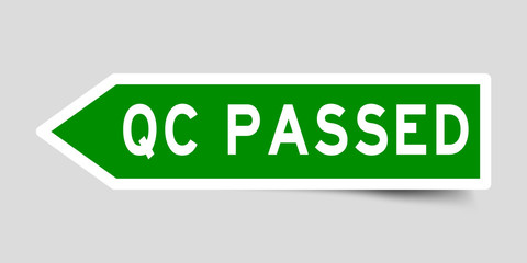 Arrow shape green color sticker in word QC (abbreviation of quality control) passed on gray background