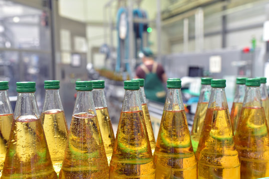 apple juice in glass bottles in a factory for the food industry - bottling and transport // Apfelsaftflaschen in einer modernen Mosterei - Fliessband in der Produktion und Abf&uuml;llung 