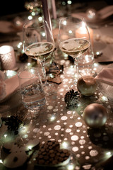 christmas eve party table with wine glass and glitter season's greeting decoration