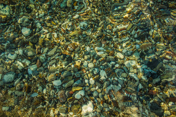 abstract unfocused fuzzy colorful stones on sea bottom surface background through the water 