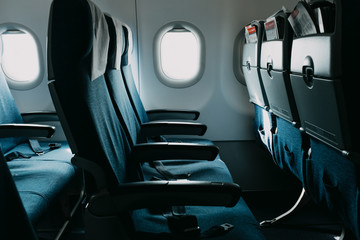 Empty blue air plane seats near open windows