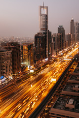 Fototapeta na wymiar Beautiful aerial view to Dubai downtown city center lights skyline in the twilight, United Arab Emirates. Long exposure light trails effect