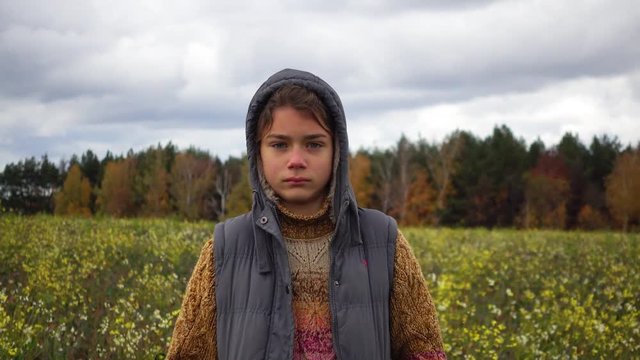Portrait of a boy in a flowered field in the fall. A boy on the background of a paradoxical flowering field in the fall.
