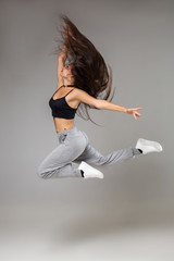 Modern style dancer posing on studio background. Hip hop, jazz funk, dancehall