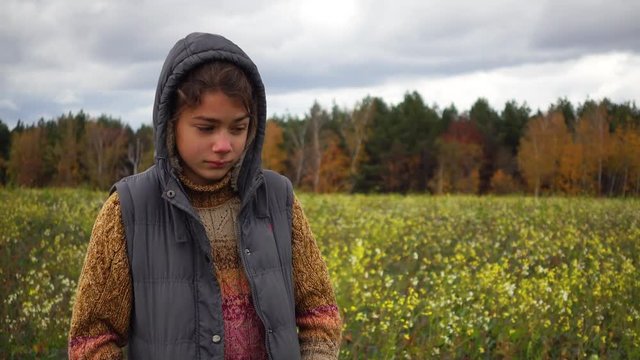 Portrait of a boy in a flowered field in the fall. A boy on the background of a paradoxical flowering field in the fall.

