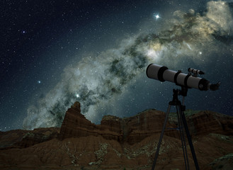 Fototapeta premium telescope on tripod looking at the milky way in night sky