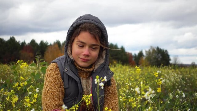 Portrait of a boy in a flowered field in the fall. A boy on the background of a paradoxical flowering field in the fall.
