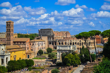 Fototapeta na wymiar Rome Forum and Coliseum cityscape, with blue sky and white clouds, Italy