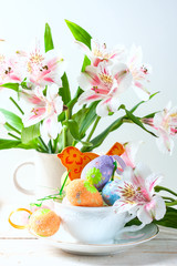 Easter eggs with spring flowers on table.