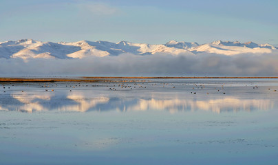 Tien Shan mountains near calm water of Son-Kul lake,natural landmark of Kyrgyzstan,Central Asia