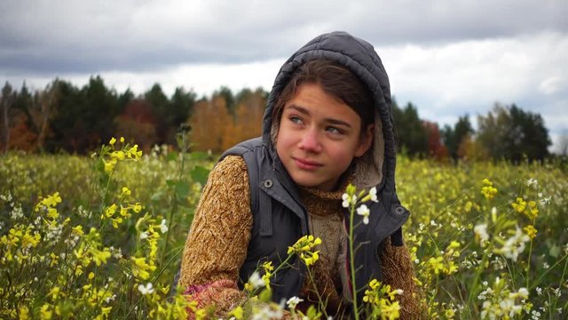 Portrait of a boy in a flowered field in the fall. A boy on the background of a paradoxical flowering field in the fall.
