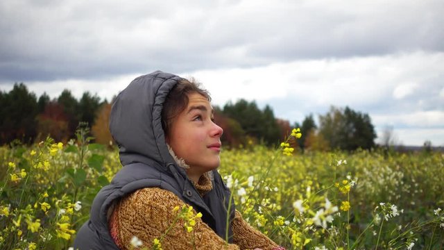 Portrait of a boy in a flowered field in the fall. A boy on the background of a paradoxical flowering field in the fall.

