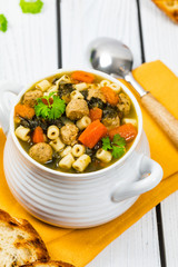 Traditional Italian-Style Wedding Soup. Made with Meatballs, Carrots and Spinach in Chicken Broth. Selective focus.