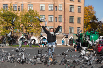 happy playful girl on the run scares pigeons