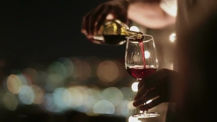 Waiter pours wine into a glass 