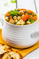 Traditional Italian-Style Wedding Soup. Made with Meatballs, Carrots and Spinach in Chicken Broth. Selective focus.