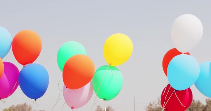 Multicolored balloons moving at wind on sky background