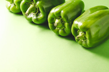 row green paprika pepper close-up/row green paprika pepper over green background, copy space