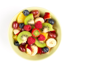 Fruit Salad in Green Bowl on white Table, Top View. copy space.