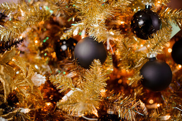 Obraz na płótnie Canvas Background of golden fir tree with small black bulbs