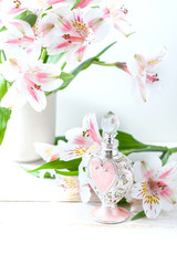 Luxurious perfume bottle with flowers on white background. Feminine beauty concept.
