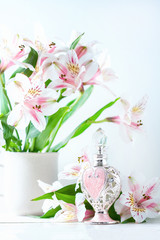Luxurious perfume bottle with flowers on white background. Feminine beauty concept.