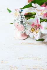 Luxurious perfume bottle with flowers on white background. Feminine beauty concept.