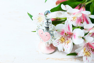 Luxurious perfume bottle with flowers on white background. Feminine beauty concept.