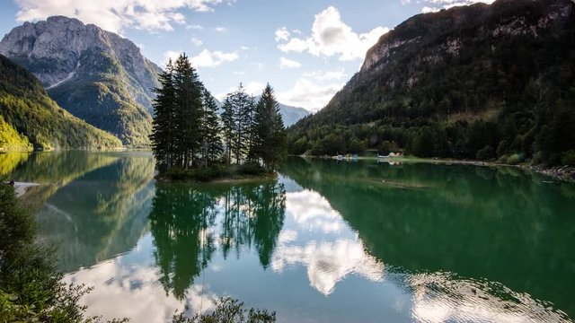 Time Lapse - Lago del Predil with trees on an island and moving clouds