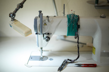 seamstress workplace. Sewing machine scissors threads and other tools. Tailoring industry