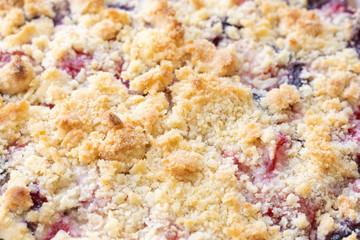 Close up on the baked crust of a berry cobbler, in a food background