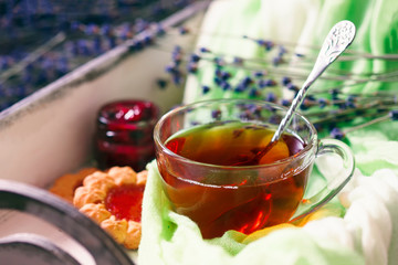 Wooden tray with cup of hot black tea with light breakfast.