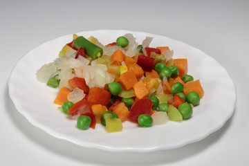 Boiled mix of vegetables, as the concept of diet. Vegan food - vegetables for breakfast. White background.