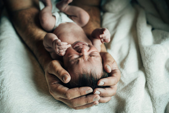 Father bonding with crying newborn