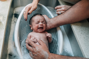 Newborn baby being given a bath