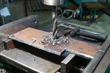 Drilling a metal plate on a drilling machine, machine-building production.